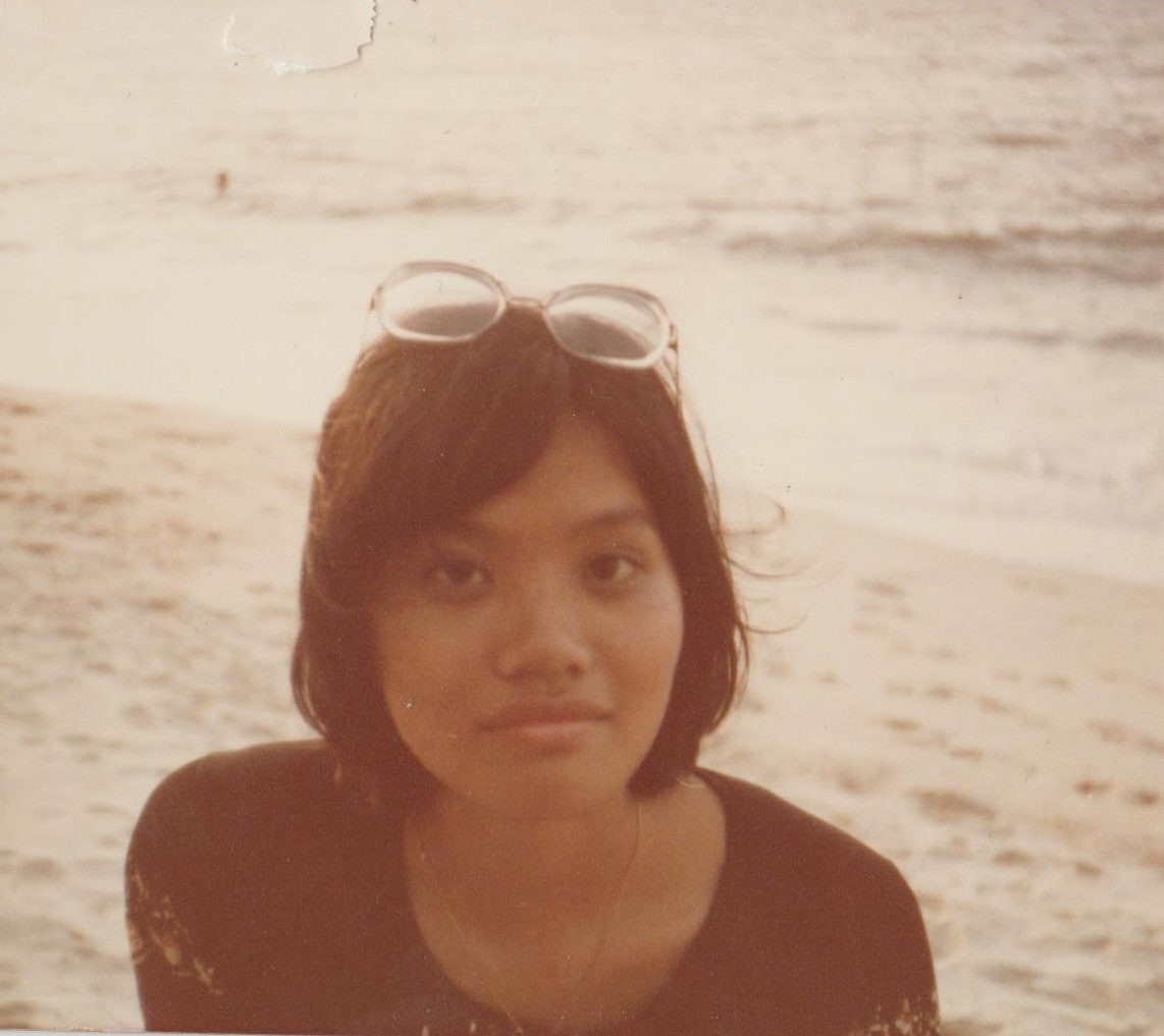 Chinese girl with mid length hair looking at the camera, with glasses above her head