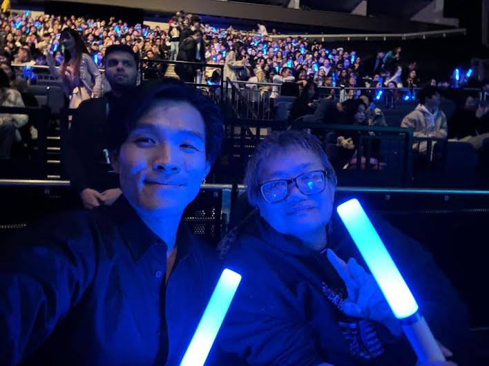 two East Asians, they are in a concert , both holding glow sticks